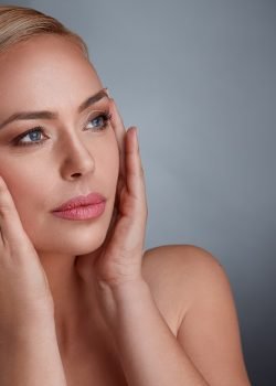 woman tightening skin on face to make you look younger woman tightening skin on face to make you look younger, middle age and aging